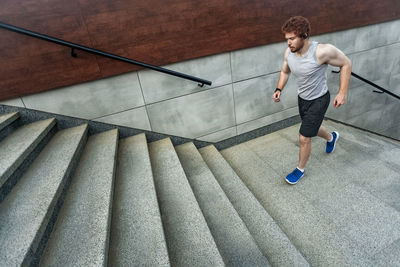 Full length of young man running on staircase