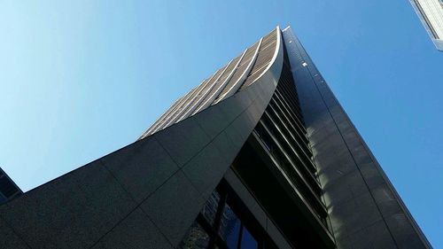 Low angle view of modern building against clear blue sky