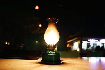 Close-up of illuminated light bulb on table