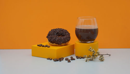 Still life photography of donut cake with chocolate topping and coffe beans