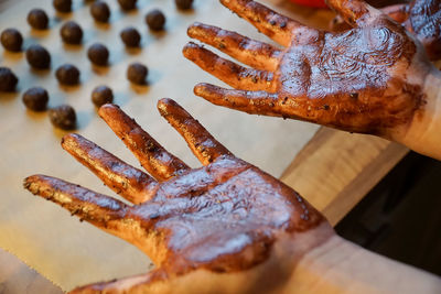 Close-up of hands covered in chocolate
