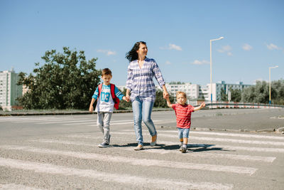 Mother and children walking on zebra crossing