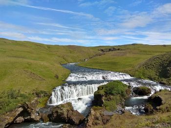 Scenic view of waterfall against sky