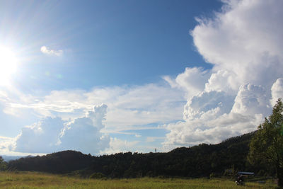 Scenic view of land and trees against sky