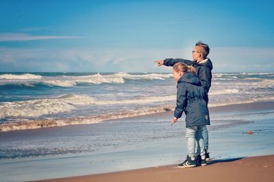 Full length of man standing on beach against sky