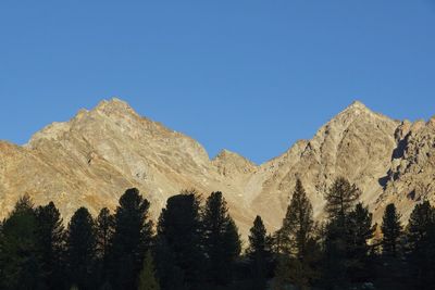 Low angle view of mountains against clear blue sky