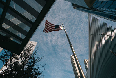 Low angle view of flags hanging amidst buildings against sky