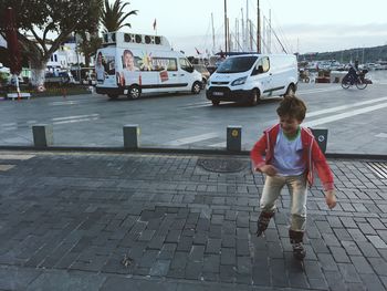 Full length of boy on street against sky