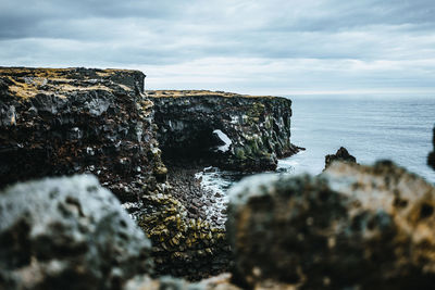 Rock formations by sea against sky