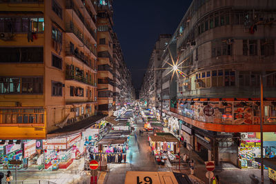 Street amidst buildings in city at night