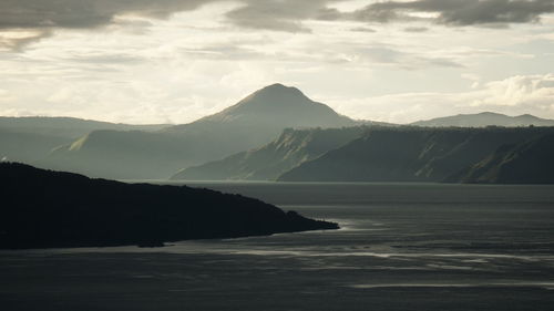 Scenic view of sea and mountains against sky