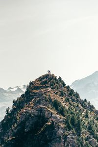 Low angle view of people on rock against sky