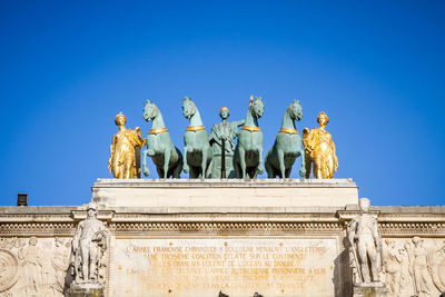 Low angle view of statue against blue sky