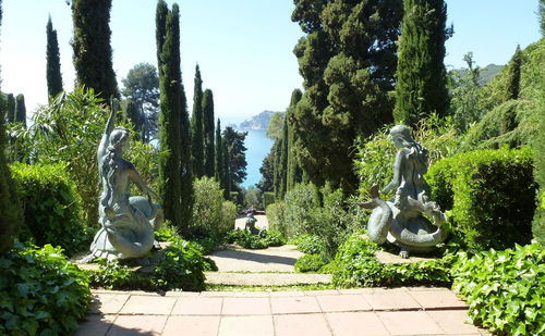 Statue amidst trees against sky