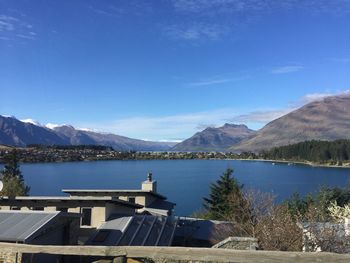 Scenic view of lake and mountains against blue sky