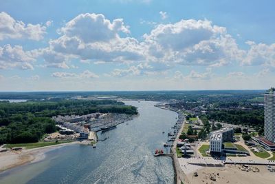 High angle view of city by sea against sky