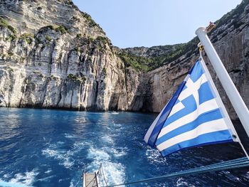 Scenic view of sea and mountains against clear blue sky