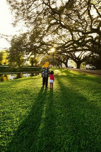 Rear view of people walking on grass