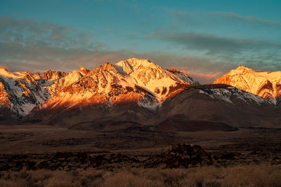 Scenic view of snowcapped mountains against sky during sunset