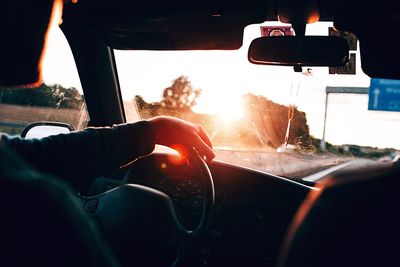 Cropped image of man in car in sunny day