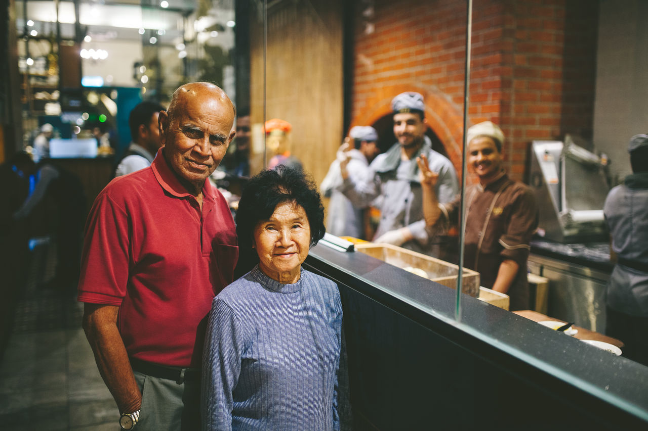 real people, men, males, adult, smiling, leisure activity, lifestyles, casual clothing, happiness, mature adult, people, mid adult, indoors, focus on foreground, group of people, mature men, incidental people, portrait, waist up