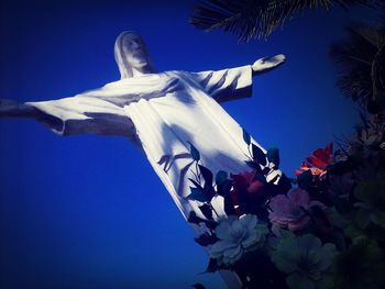 Low angle view of statue against blue sky