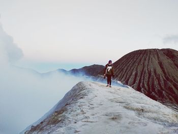 Man standing on mountain against sky