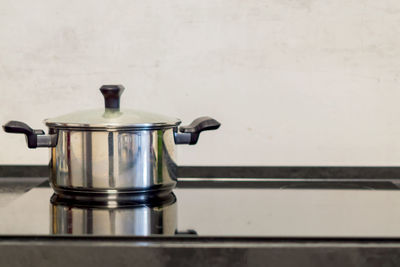 Chrome pot on electric stove, modern black and white kitchen
