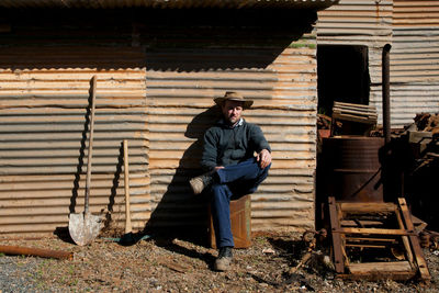 Men sitting against barn