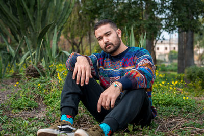 Caucasian model sitting on the ground in a public park