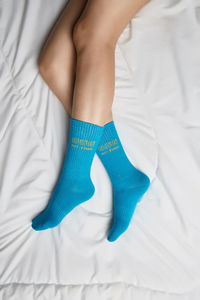 Low section of woman relaxing on bed