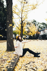 Woman standing by plants during autumn