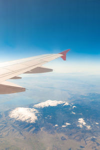 Aerial view of aircraft wing against blue sky