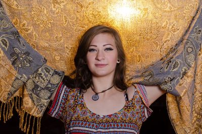 Portrait of beautiful young woman standing against wall