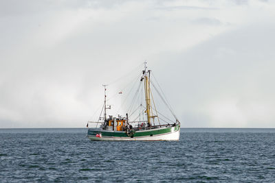 Sailboat sailing on sea against sky