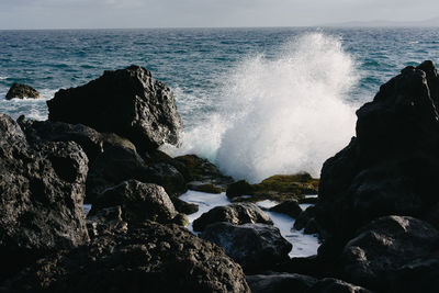 Scenic view of rocks in sea against sky