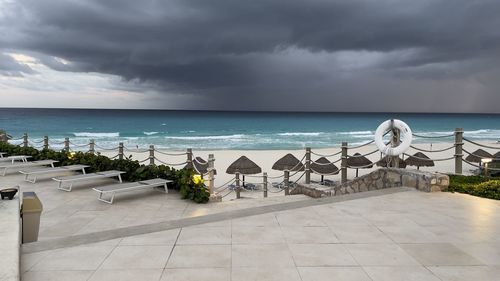 People at beach against cloudy sky