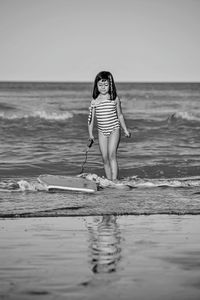 Full length of young woman standing at beach