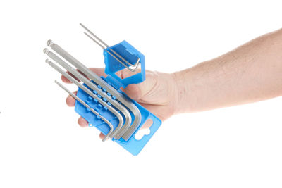 Close-up of hand holding toy over white background