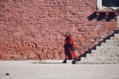 Rear view of a man walking on cobblestone