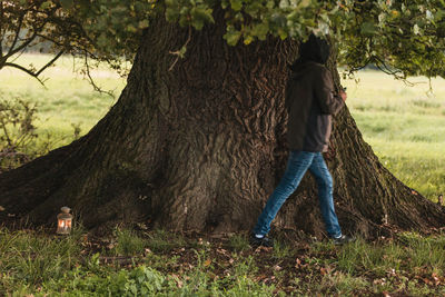 Full length of man on tree trunk in field