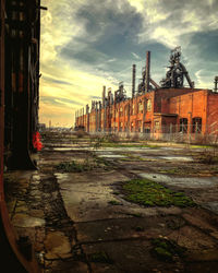 Railroad tracks by buildings in city against sky during sunset