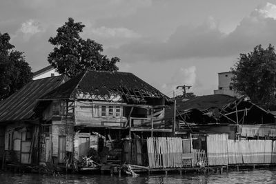 Houses by building against sky