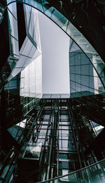 Low angle view of glass building against sky