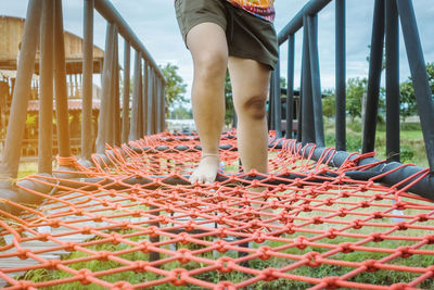 Low section of woman standing on railing