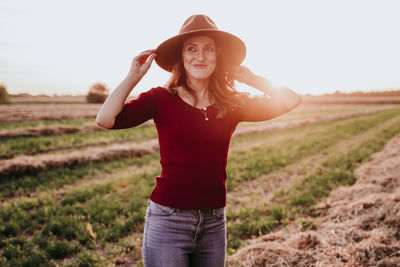 Portrait of smiling young woman standing on field