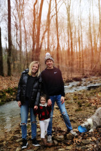 Portrait of teenage girl standing with brother and sister at forest