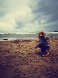 Full length of woman sitting on beach