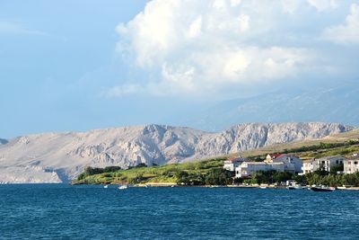 Scenic view of sea by buildings against sky