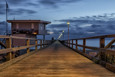 View of pier on bridge against cloudy sky